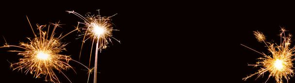 Ευτυχισμένο το Νέο Έτος - Σιλβέστερ φόντο πανόραμα long-sparklers σε σκούρο μαύρο ουρανό νύχτα υφή - Φωτογραφία, εικόνα
