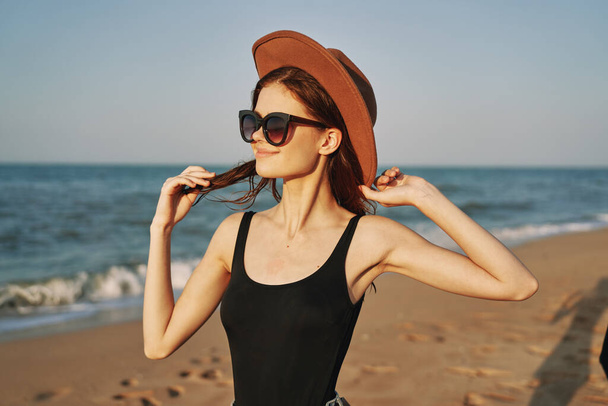 woman in a hat sunglasses by the ocean travel sun - Valokuva, kuva