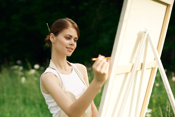 woman artist paints a picture near easel outdoors landscape creative - Fotó, kép