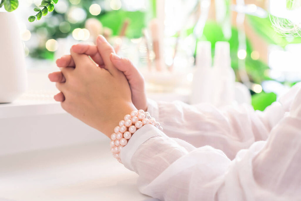 Woman praying while sitting near dressing table - Photo, image