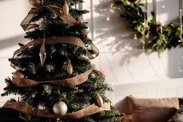 Puu on koristeltu värikkäillä leluilla ja seppeleellä. Lähikuva valokuva lämpimin värein. Joulu ja uudenvuoden tunnelma - Valokuva, kuva