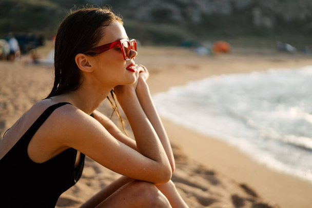 woman in a black swimsuit on the beach sea Summer vacation - Фото, зображення