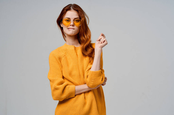 red-haired woman in yellow glasses posing on  light background. High quality photo - Photo, Image