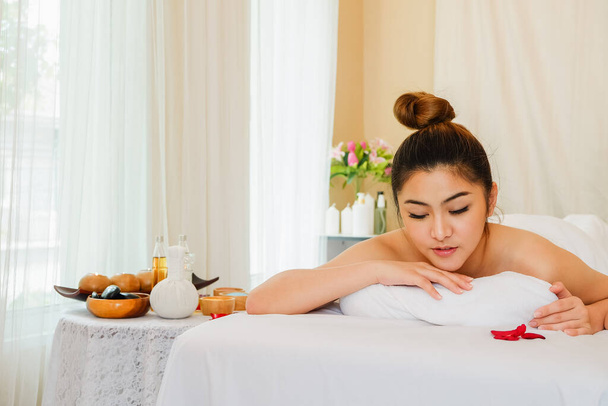 Jovem mulher asiática relaxante no spa massagem mentira em seu estômago na cama - Foto, Imagem