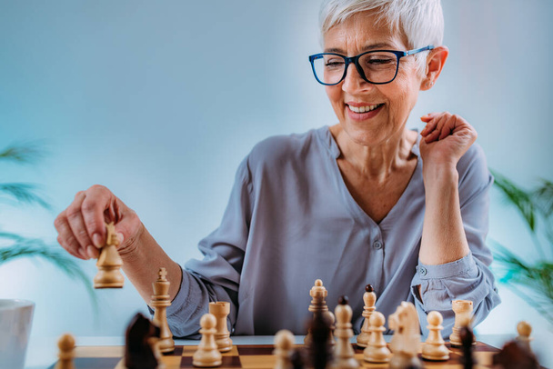 Femme âgée jouant aux échecs. Activité de réadaptation cognitive. - Photo, image