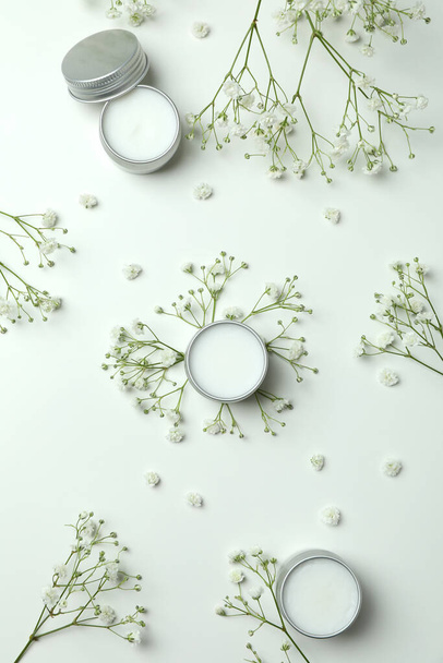 Eco lip balm and flowers on white background - Фото, изображение