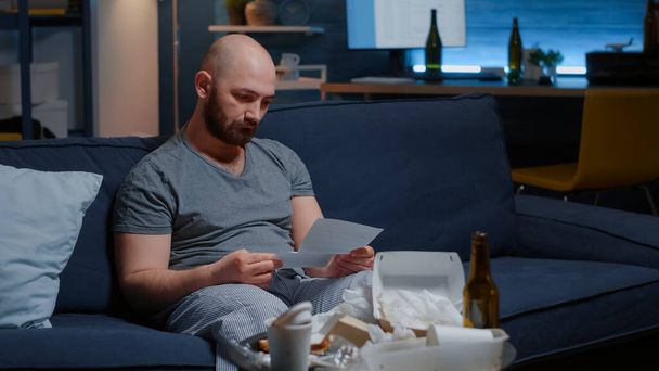 Triste irritado homem leitura despejo aviso segurando papel lette - Foto, Imagem