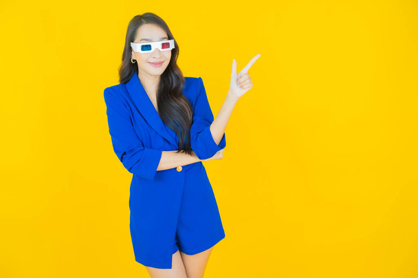 ritratto di bella donna asiatica in 3d occhiali su sfondo giallo - Foto, immagini
