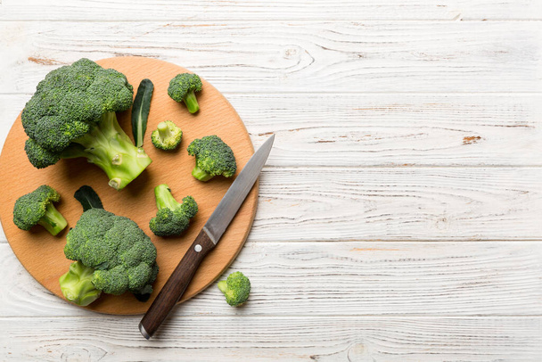 fresh green broccoli on wooden cutting board with knife. Broccoli cabbage leaves. light background. Flat lay. - Zdjęcie, obraz