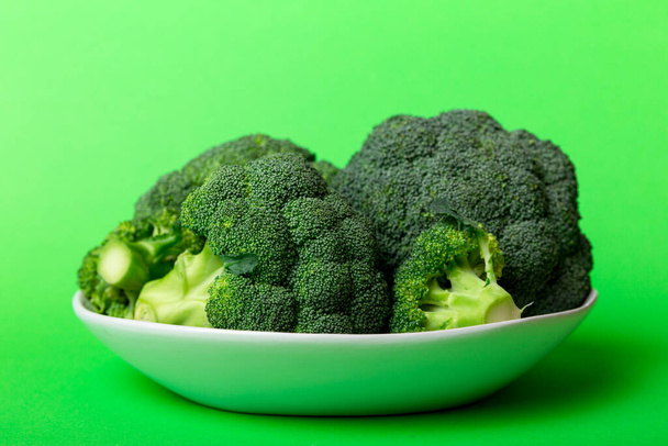brokkoli friss zöld brokkoli tálban színes háttér. Zárj be! Friss zöldség. - Fotó, kép