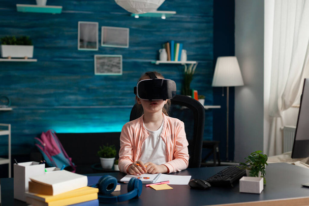 Kleines Schulkind mit Virtual-Reality-Headset genießt das Spiel mit der VR-Brille - Foto, Bild