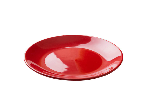 Red ceramic round plate isolated over white background. perspective view. - Photo, Image