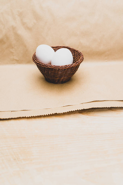 organic white eggs in a canister on a natural wooden and paper background with copy space for text - Fotoğraf, Görsel