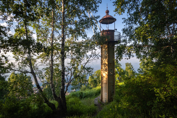 Old lighthouse among trees on the shore of Lake Baikal - Fotoğraf, Görsel