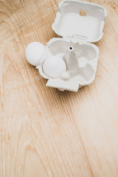 cardboard egg box made of recyclables materials with space for text on a wooden tabletop - Fotoğraf, Görsel