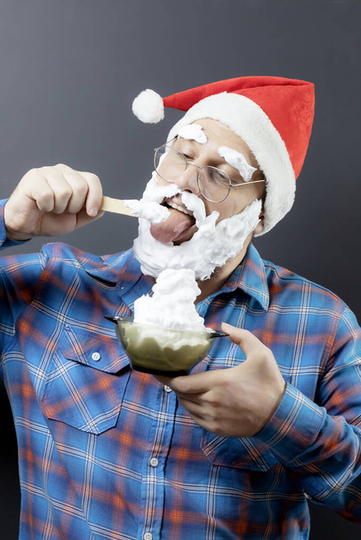 Весёлый замаскированный Санта ест мороженое. Фальшивый Санта. Рождественский плакат. Борода и брови - Фото, изображение