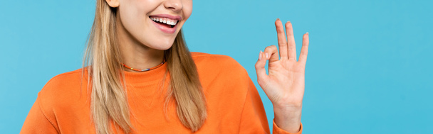 Cropped view of smiling young woman showing okay gesture isolated on blue, banner  - Φωτογραφία, εικόνα