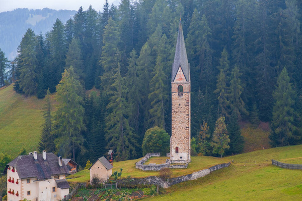 Kościół Santa Barbara w przytulnej wiosce La Valle w mglisty poranek, Alta Badia, Południowy Tyrol we Włoszech, Europa - Zdjęcie, obraz