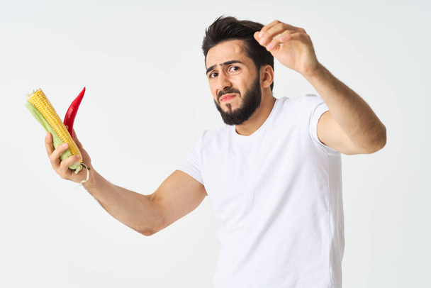 bearded man with vegetables in his hands hot pepper corn - Photo, image