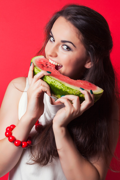 Young woman biting watermelon - 写真・画像