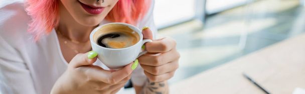 cropped view of pierced manager with pink hair holding cup of coffee in office, banner - Fotoğraf, Görsel