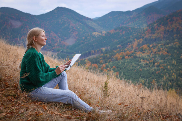 Young woman drawing on tablet in mountains - Zdjęcie, obraz