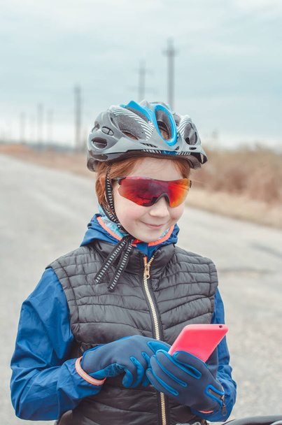Egy fiatal biciklis portréja. Az utazó útbaigazítást keres térképeket használva okostelefonján - Fotó, kép