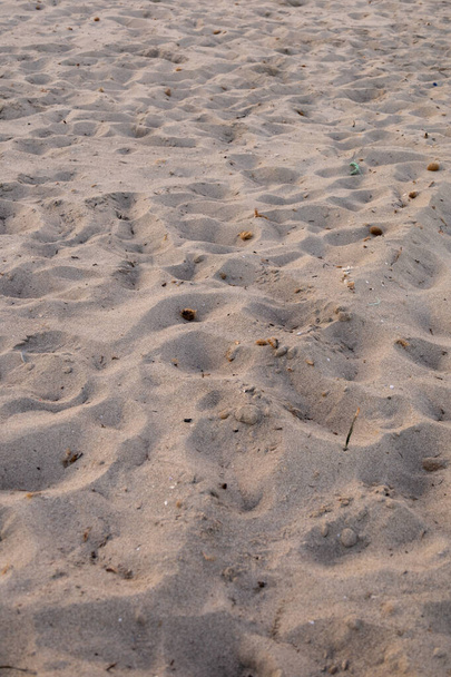 A vertical shot of footsteps on the sandy beach - Foto, afbeelding