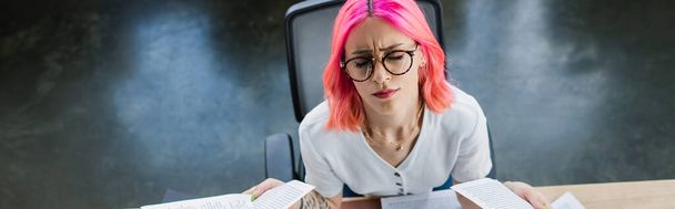 vista superior de empresária cansada com cabelo rosa segurando documentos no escritório, banner - Foto, Imagem