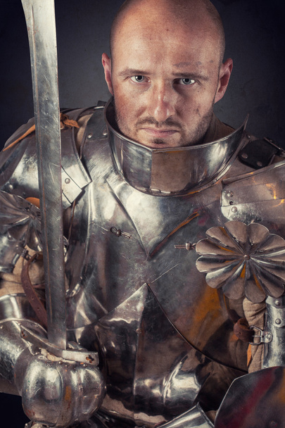 Knight wearing armor and holding sword - Fotó, kép