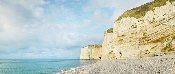 Picturesque panoramic low angle view of the Etretat white cliffs. Clear blue sky, azure water. Summer vacations in Normandy, France. Travel destination, national landmark, sightseeing, history - Photo, Image