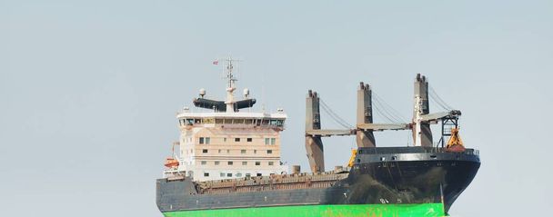 Gran granelero (buque grúa de carga) navegando en el mar Báltico hasta el puerto de Riga, Letonia. Una vista desde el yate. Comunicaciones globales, logística, industria, transporte de mercancías - Foto, imagen