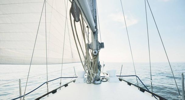Fehér jacht vitorlázás egy napos nyári napon. Közelkép a fedélzetről az orrra, árbocra és vitorlára. Hullámok és vízcsobbanások. Tiszta kék ég. Finn-öböl - Fotó, kép