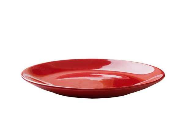 Czerwona ceramiczna okrągła płyta izolowana na białym tle. punkt widzenia. - Zdjęcie, obraz