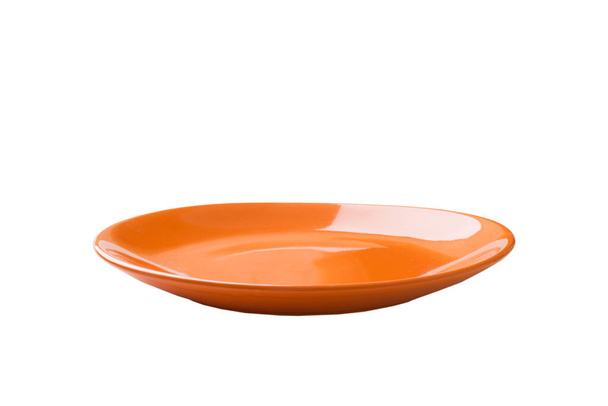 Orange ceramic round plate isolated over white background. perspective view. - Photo, Image