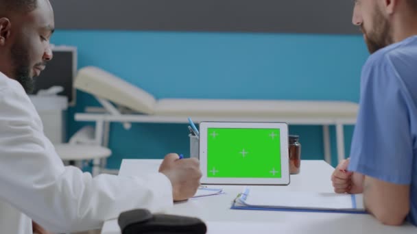 Πολυεθνική ομάδα που εξετάζει mock up πράσινο οθόνη chroma κλειδί tablet υπολογιστή - Πλάνα, βίντεο