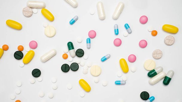 Variety of drugs in capsules and pills of different colors on a white background - Photo, Image