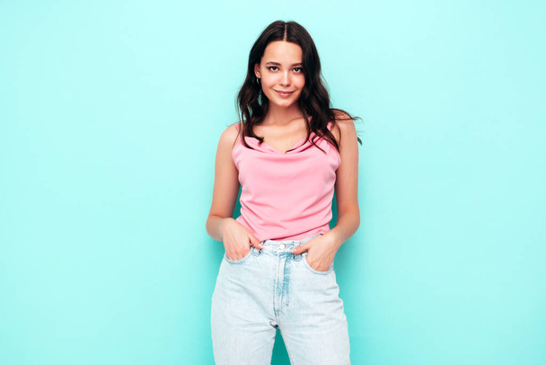 Young beautiful smiling female in trendy summer clothes. Sexy carefree woman posing near blue wall in studio. Positive brunette model having fun and going crazy. Cheerful and happy  - Φωτογραφία, εικόνα