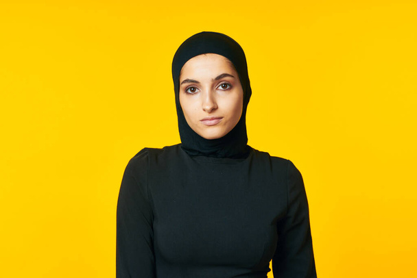 donna in abiti musulmani posa islam sfondo giallo - Foto, immagini
