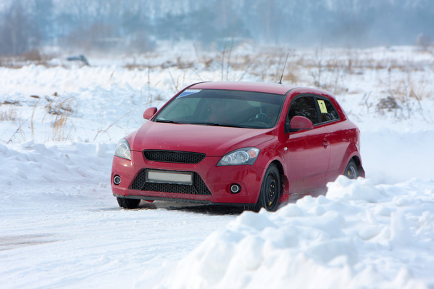 κόκκινο αγωνιστικό αυτοκίνητο στην πίστα αγώνων του χειμώνα - Φωτογραφία, εικόνα