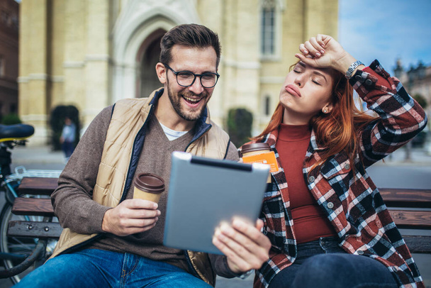 Trendy young couple in town using tablet and credit card. - Photo, Image