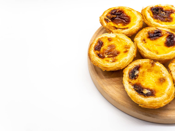portughese dessert pasteis de nata on wooden plate on white background with copy space - Photo, Image