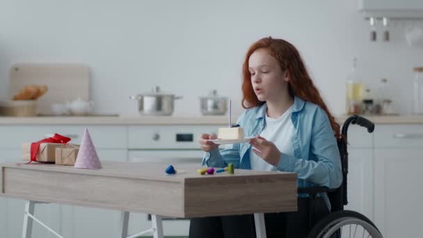 Gestresstes kleines Mädchen mit Behinderung bläst Kerze auf Geburtstagstorte an und schaut traurig zur Seite, fühlt sich allein - Filmmaterial, Video