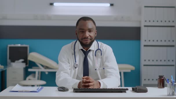 オンラインビデオ通話中に遠隔患者を聞いているアフリカ系アメリカ人セラピストの医師のポフ - 映像、動画