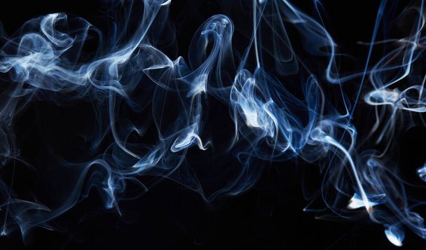 blauwe rook op zwarte achtergrond met abstracte waas beweging golf werveling. Wisp of Smoke. Sigarettenrook golven en wolken textuur - Foto, afbeelding