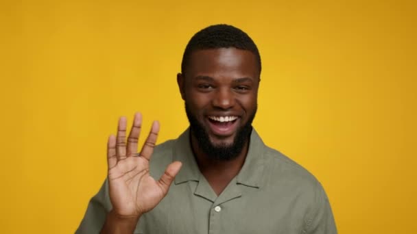Jó napot! Portré pozitív vidám fekete fickó integető kéz a kamera - Felvétel, videó