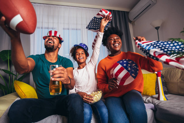 Familie schaut amerikanisches Fußballspiel zuhause im Fernsehen - Foto, Bild