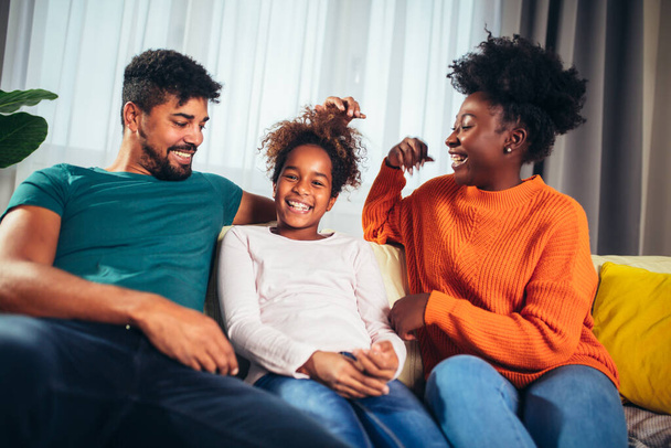 Χαριτωμένη αφροαμερικανική οικογένεια απολαμβάνοντας το χρόνο μαζί στο σπίτι. - Φωτογραφία, εικόνα