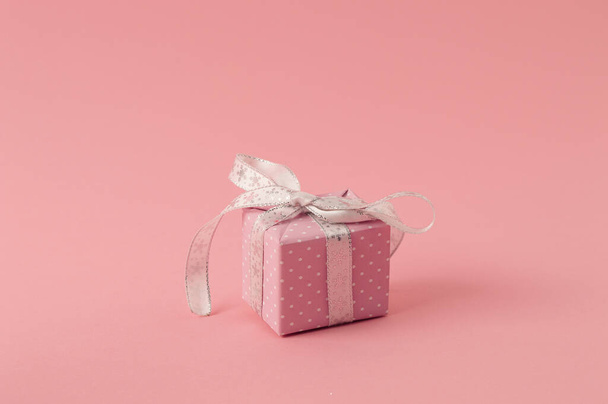 Розовый пастельный новогодний подарок на розовом фоне. Концепция Рождества. - Фото, изображение