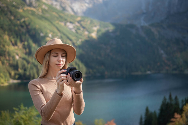 手のデジタル写真カメラで保持山の上に緑の上に立って写真家の観光客の旅行者。ハイカーは写真を撮る、女の子は旅行、リラックスして休日の概念で自然のパノラマの風景を楽しむ - 写真・画像